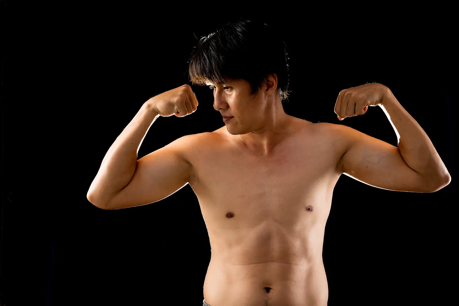 Young Confident Asian Man Shirtless Posing Rising Two Arms Muscl
