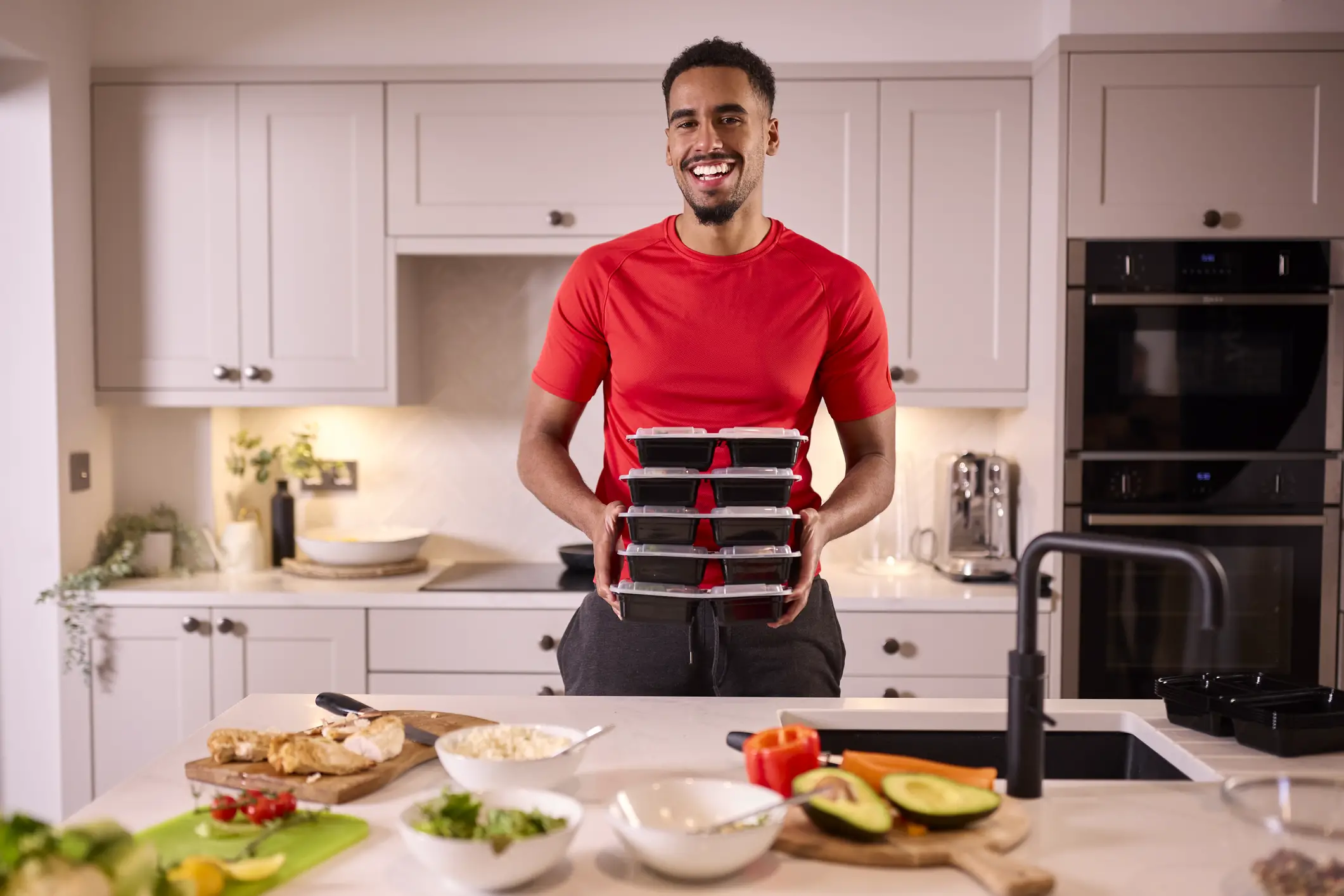 Man preparing several fitness meals to support his fitness goals
