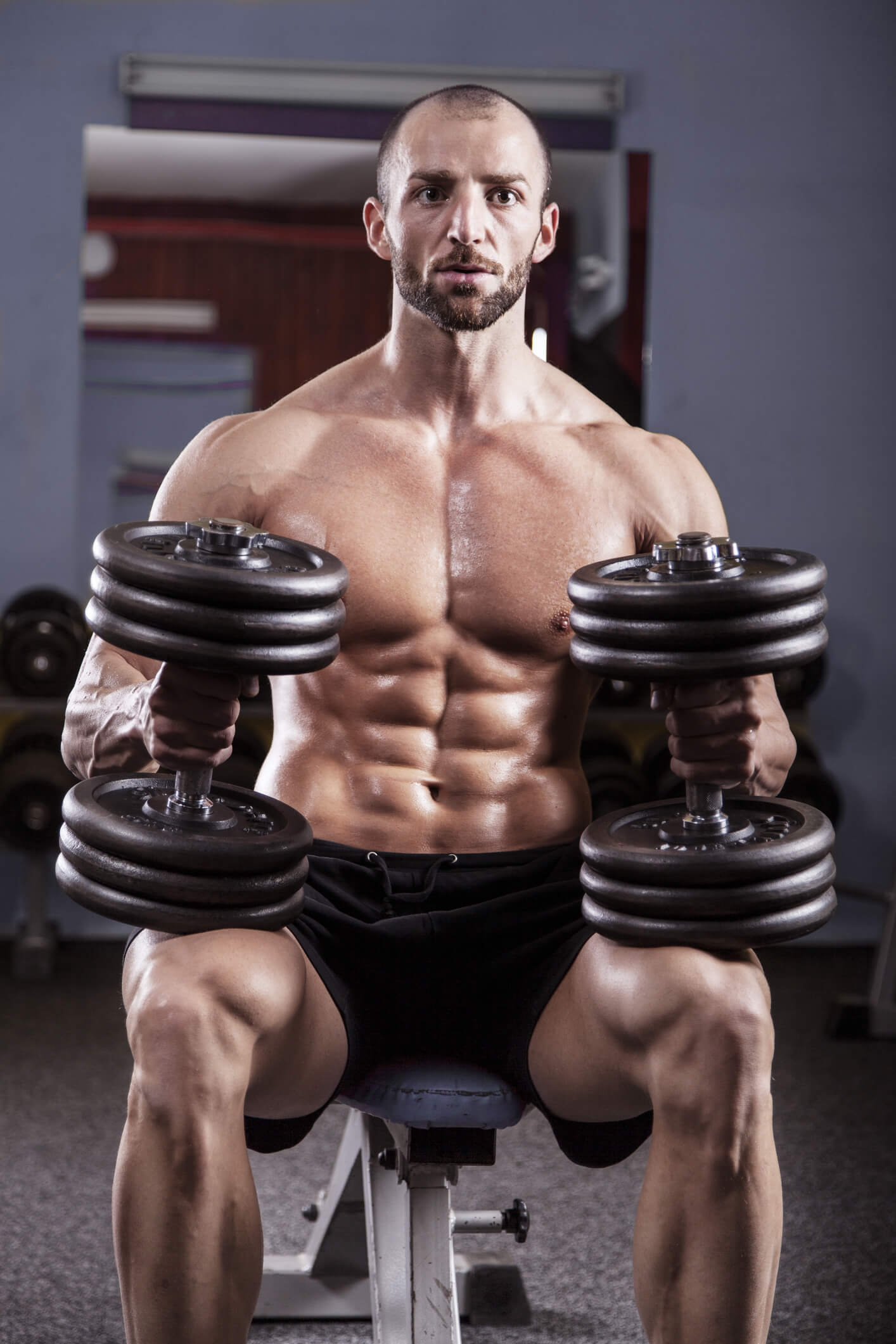 Man with dumbbells and ripped abs