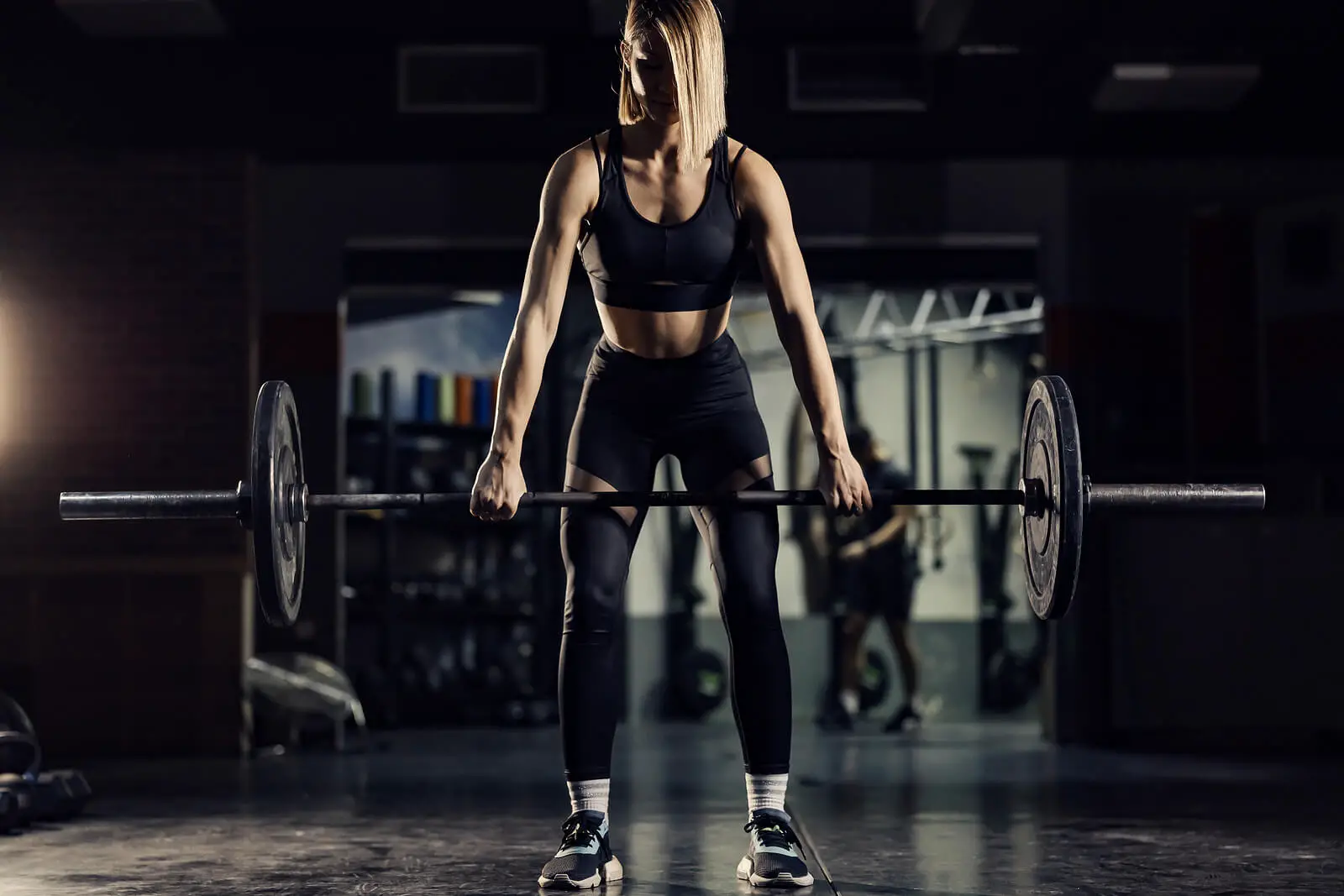 A Muscular Woman Exercising And Lifting Weights In A Gym. Streng