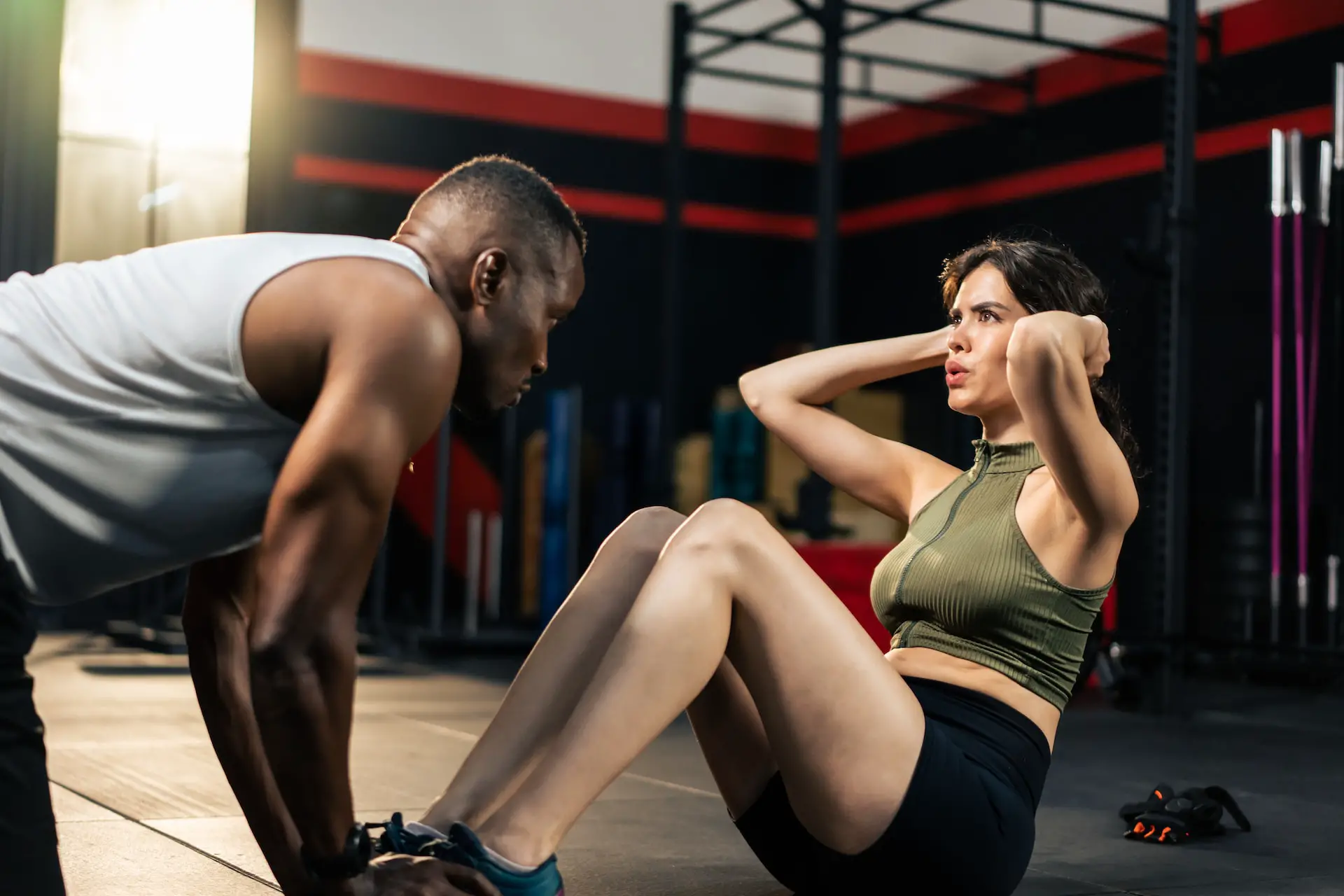 Partner assisting woman doing situps