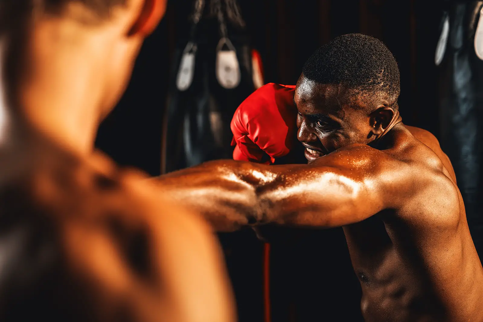 African American Black Boxer Punching At Trainer Or Coach Wearin