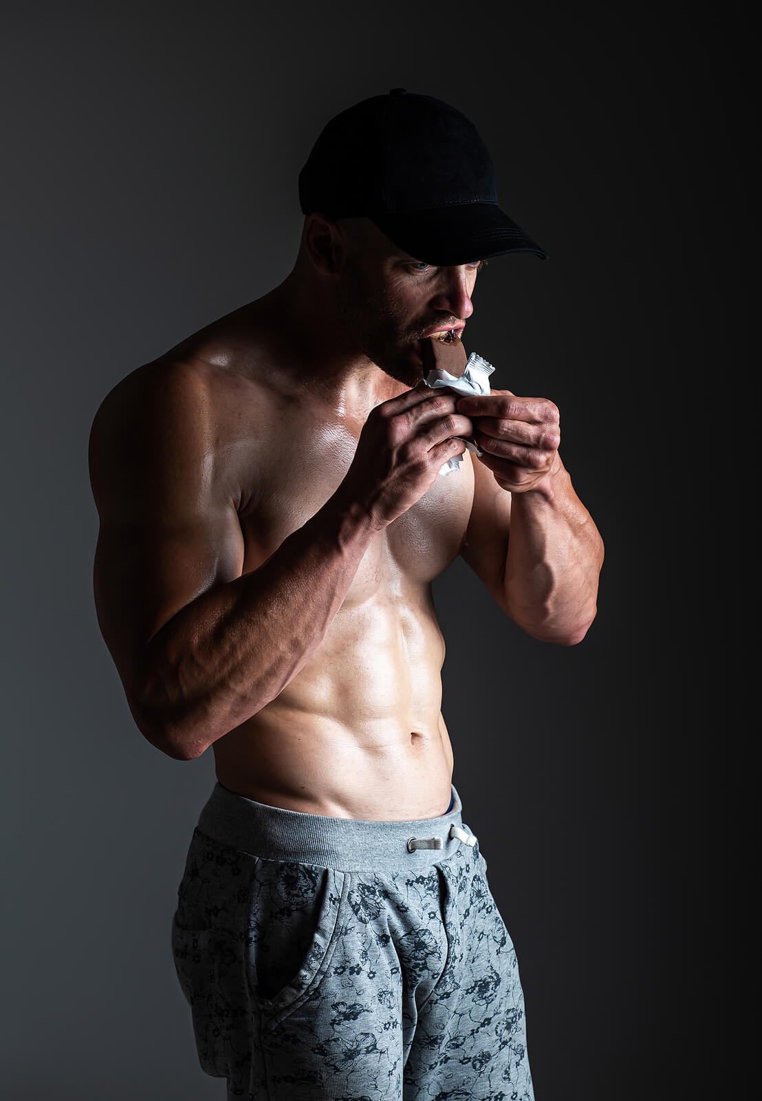 Muscle Bodybuilder Eating Carbohydrate Protein Bar During Workou