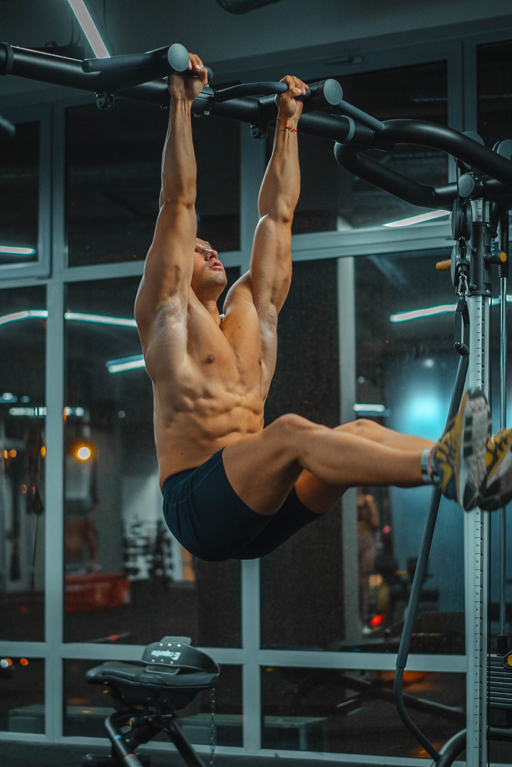 Man doing a hangling leg raise to strengthen his abs
