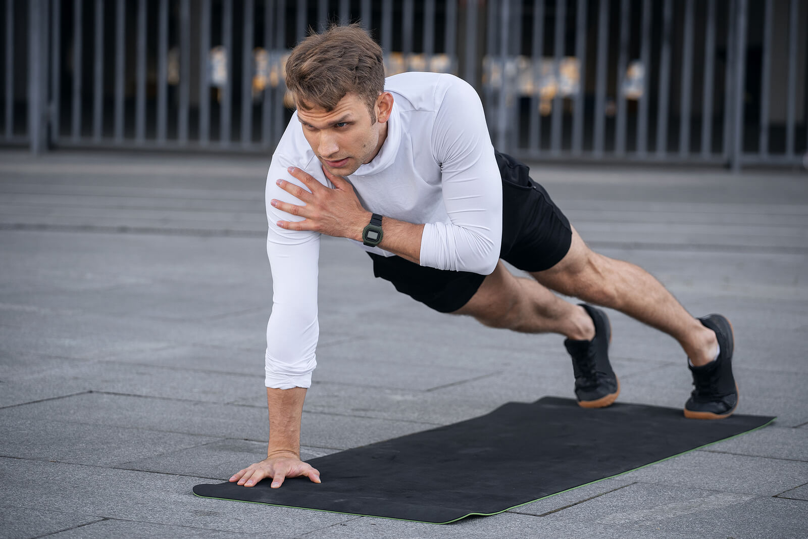 Focused Man In Sportswear Doing Shoulder Tap In Push Or Press Up