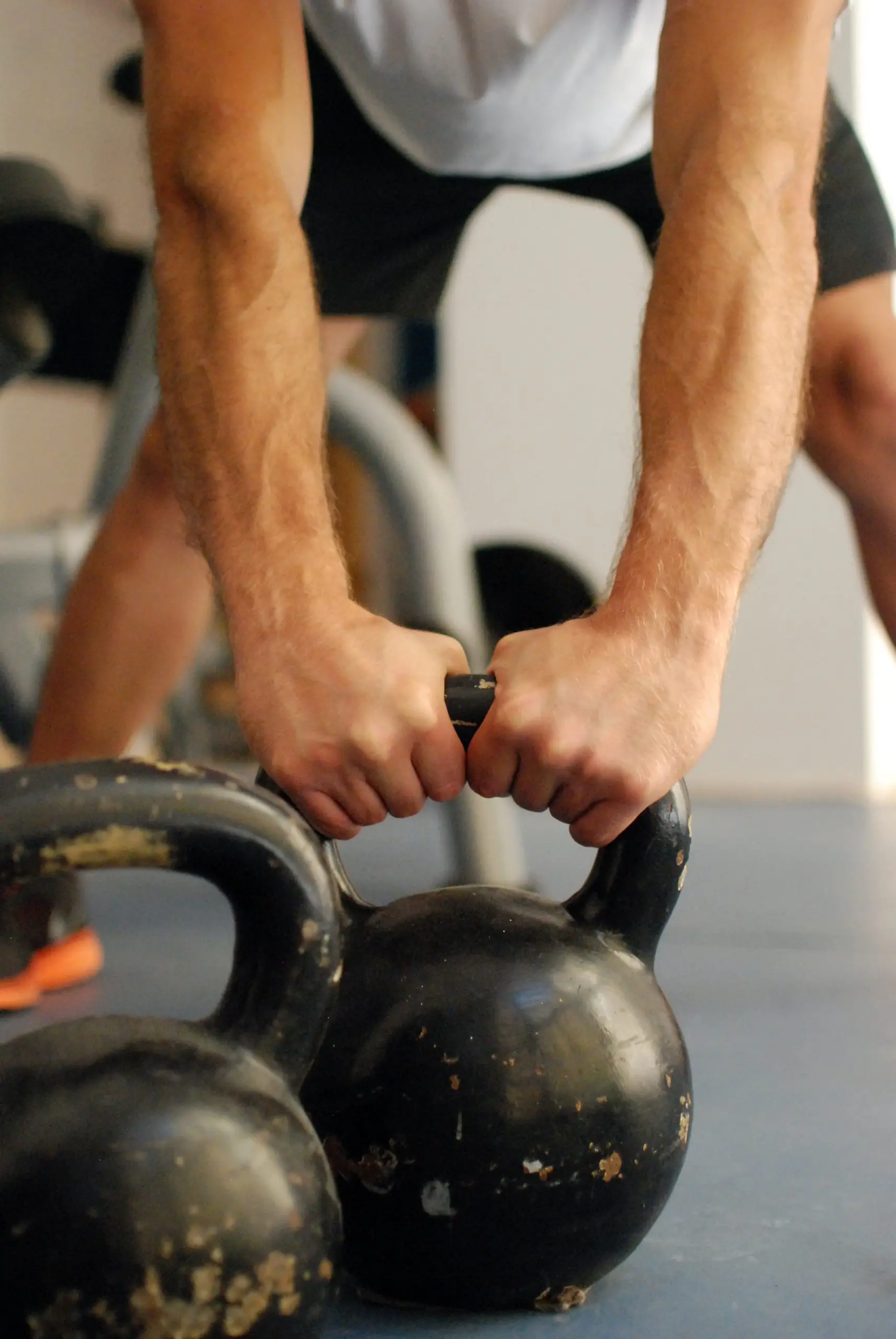 Man picking up a kettle bell to do a swing up exercise