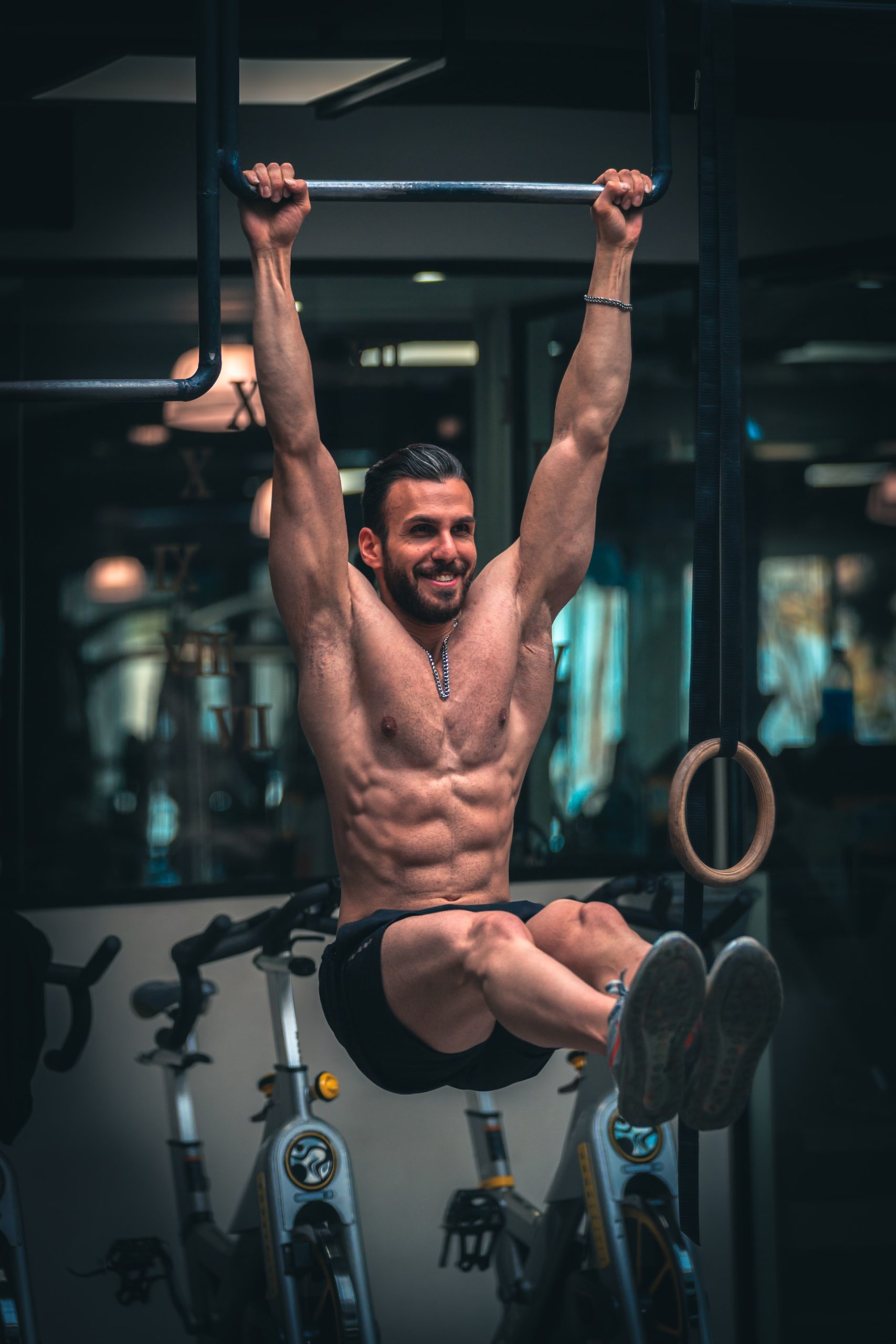 Man performing a hanging leg raise as part of his pilates routine
