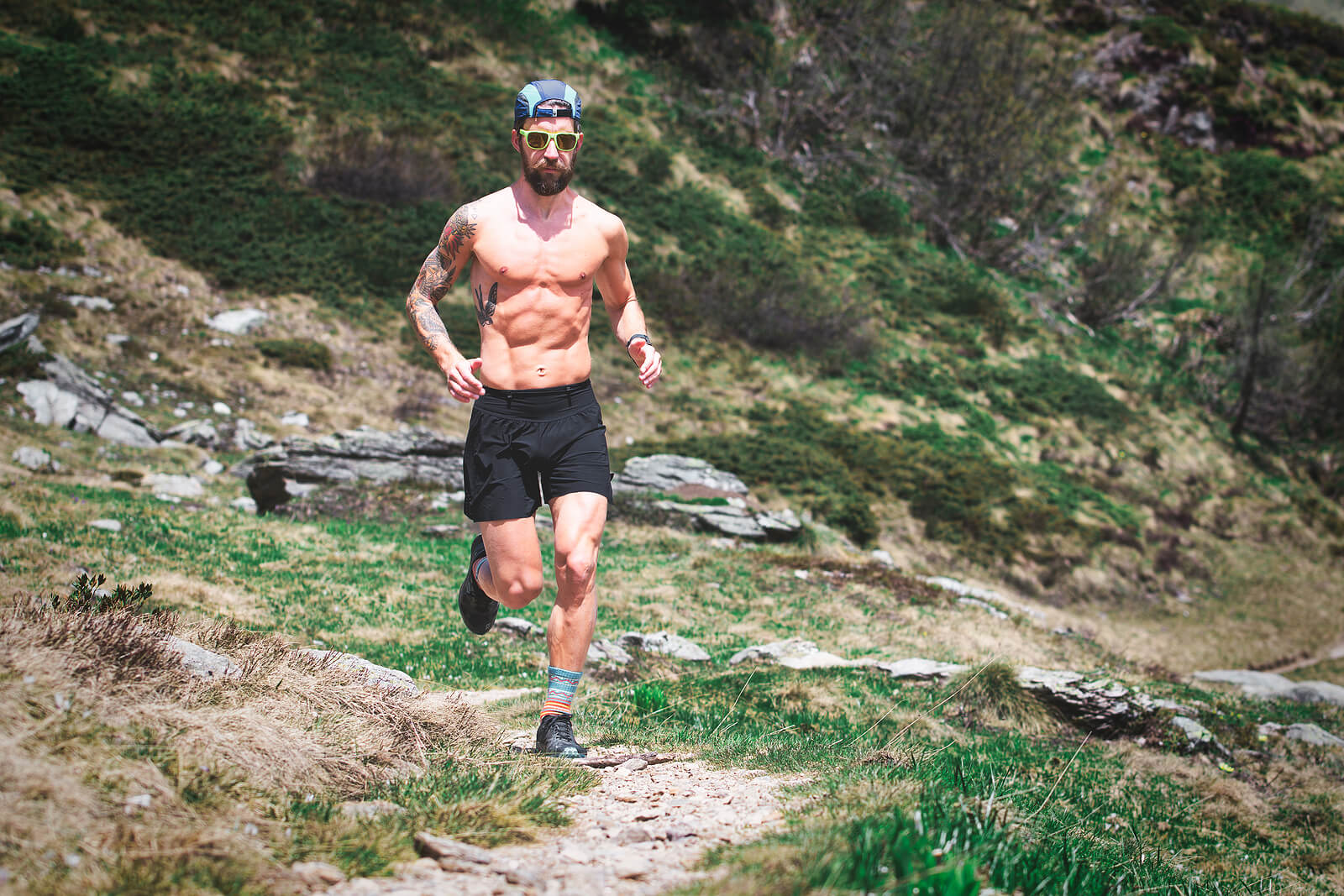 A Sporty Young Man With Muscles Runs On A Mountain Trail