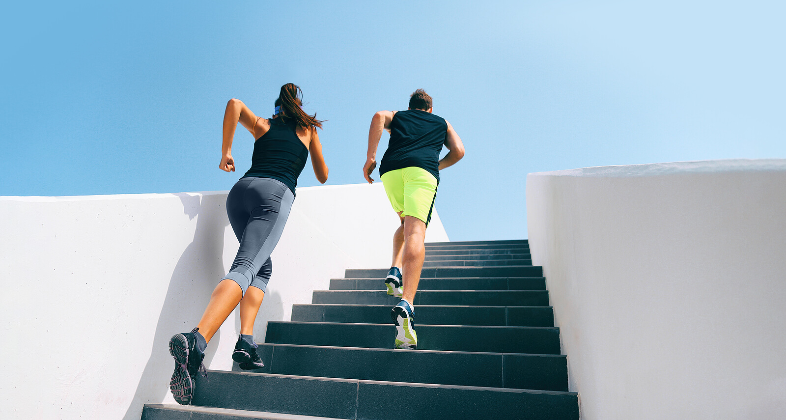 Stairs runners running up staircase training hiit workout. Coupl