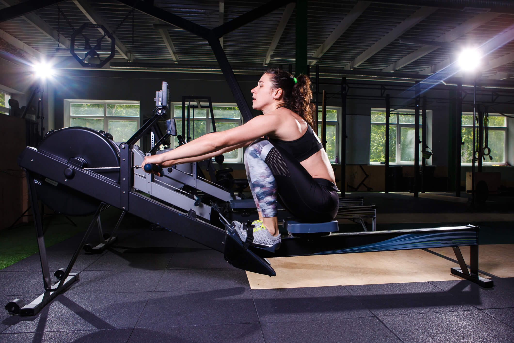 Young woman training on a rowing machine for her abs